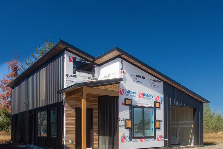 A partially constructed kit home. Insulation and vapor barrier is exposed
