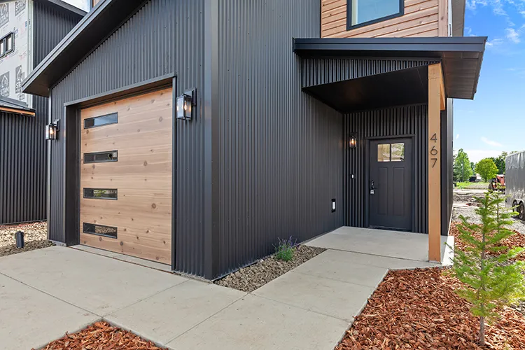 A kit culture family home in Washington that is black with wood look trim