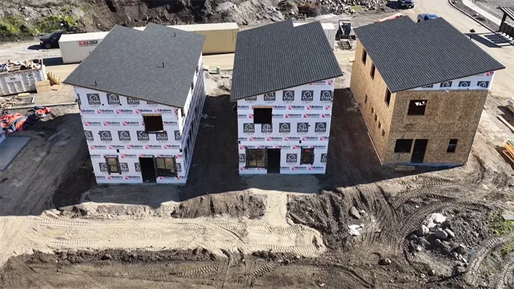 Three kit homes are pictured under various phases of construction