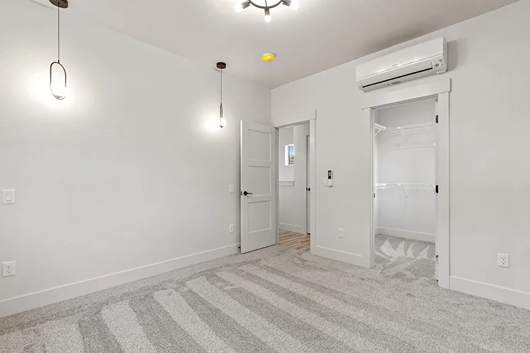 A kit culture living room interior with a ductless heat pump installed on the wall