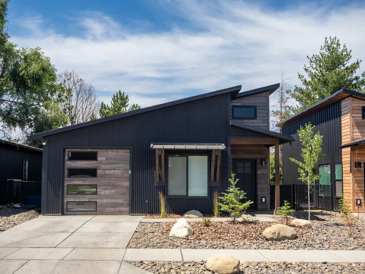 Modern energy-efficient kit home in Idaho with black metal siding and large Low-E picture windows
