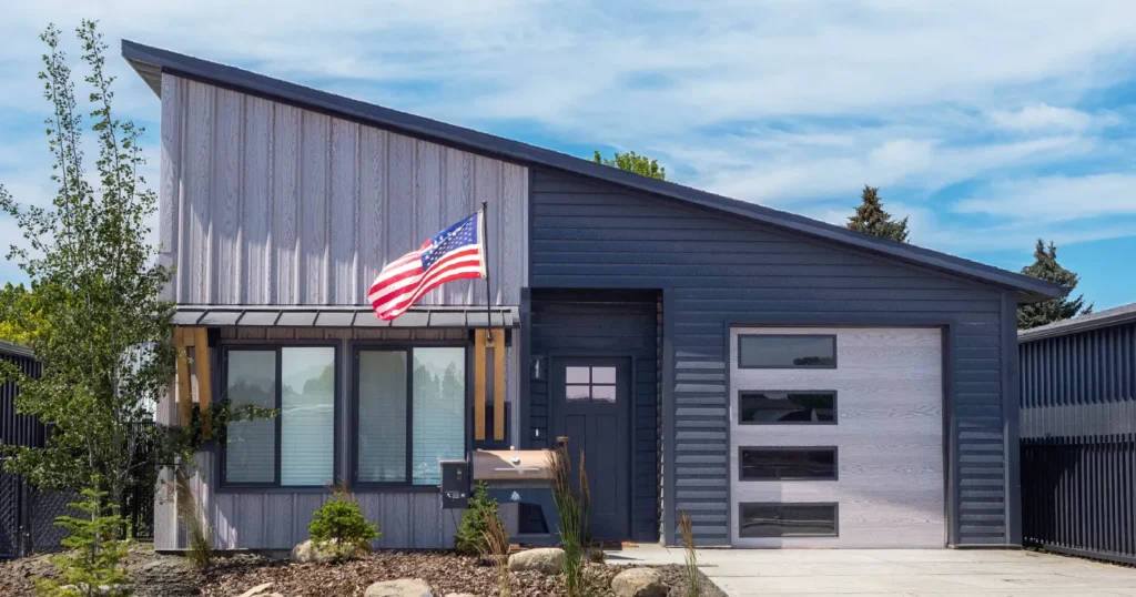A kit home that will hold its value over time. Two tone, metal siding and an american flag on display.