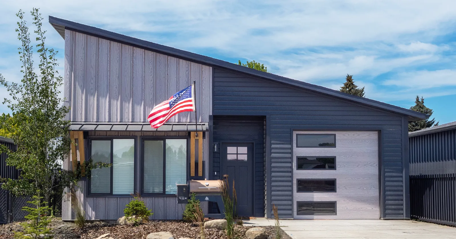 A kit home that will hold its value over time. Two tone, metal siding and an american flag on display.