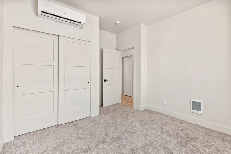 Bedroom with a mini-split heat pump in a Cottage kit home, the kind of room a guest house kit gives visitors
