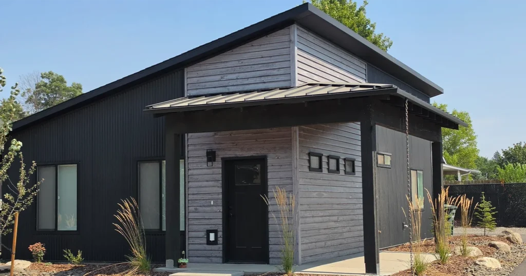 Cottage kit home exterior in Idaho with black metal and wood siding, sized to work as an ADU for adult children